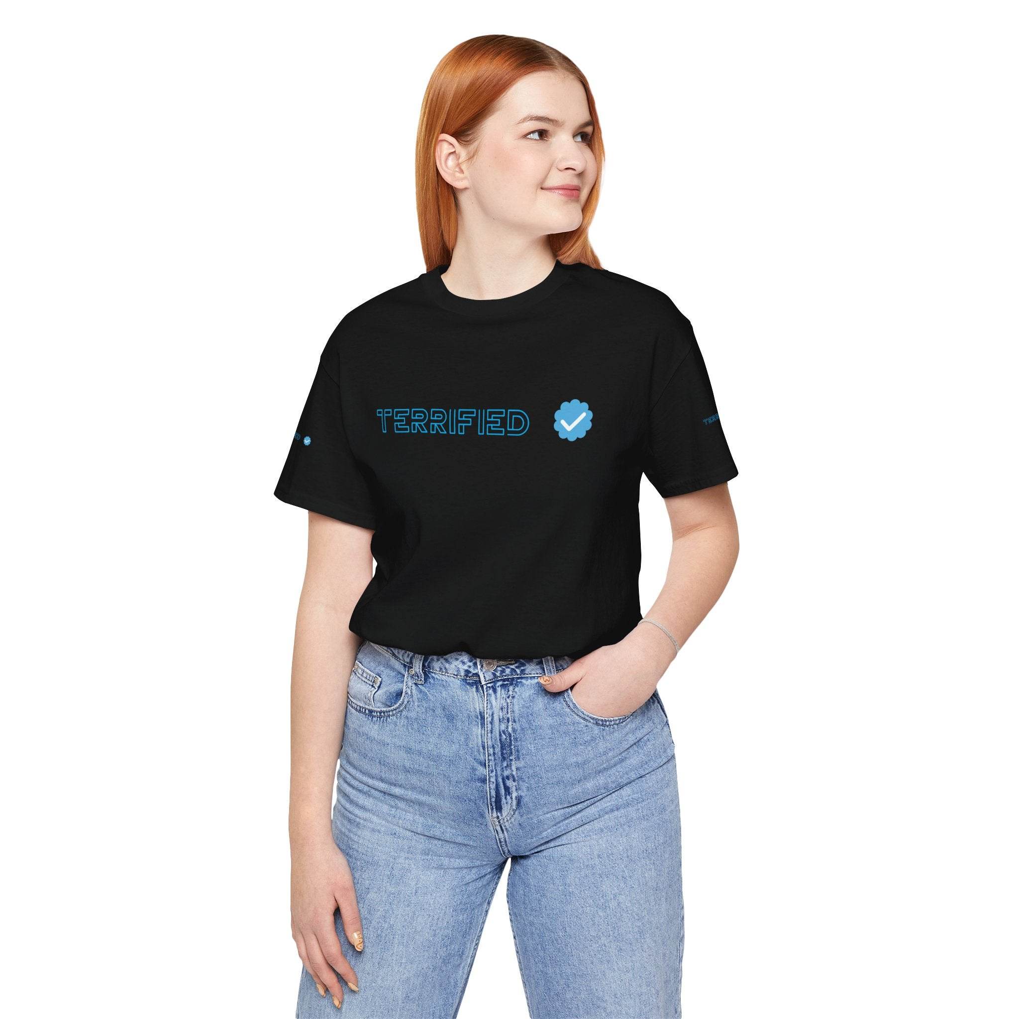 Black Printify T-shirt with Terrified text and blue checkmark worn by woman with red hair and blue jeans
