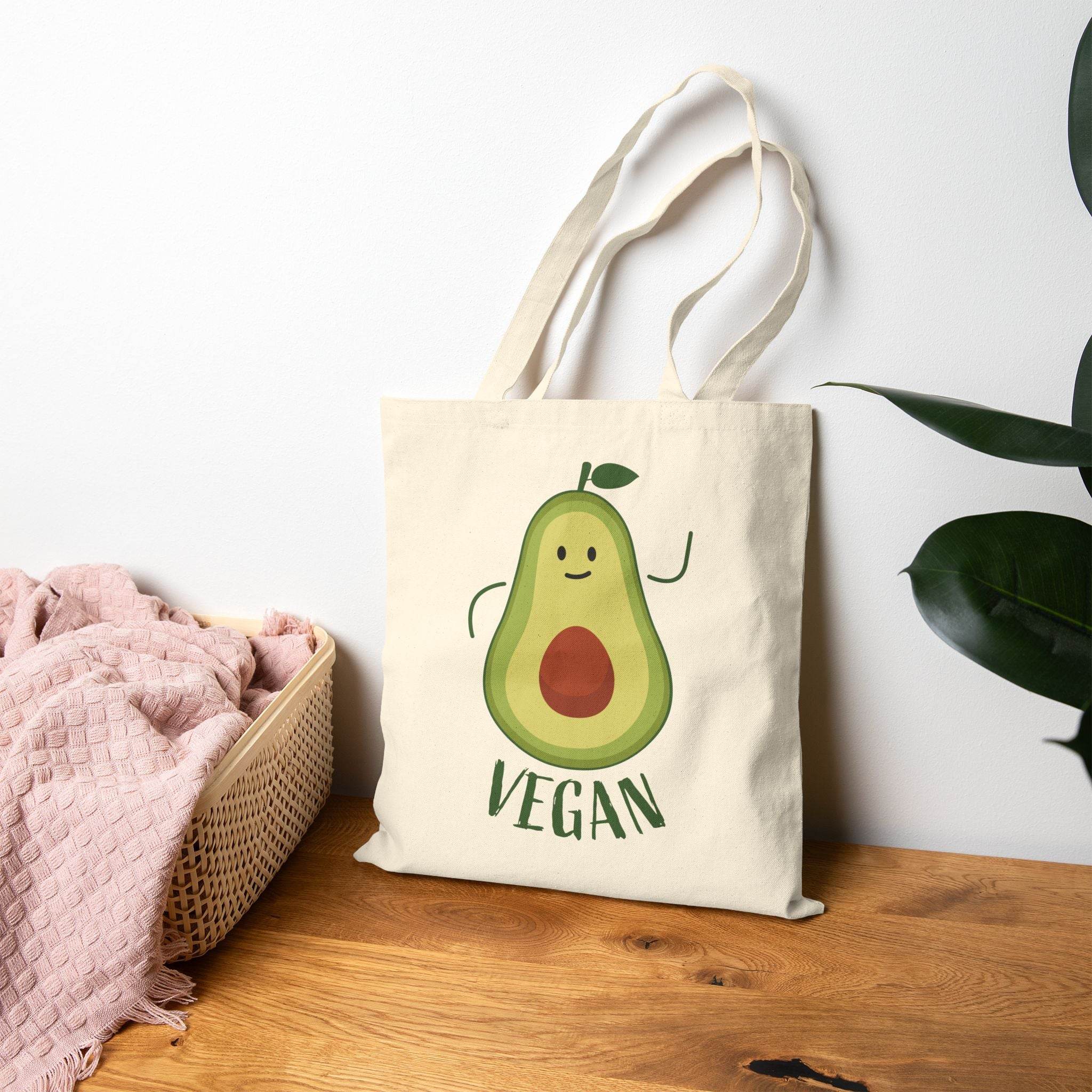 Printify eco-friendly cotton tote bag with cute avocado vegan design on wooden surface