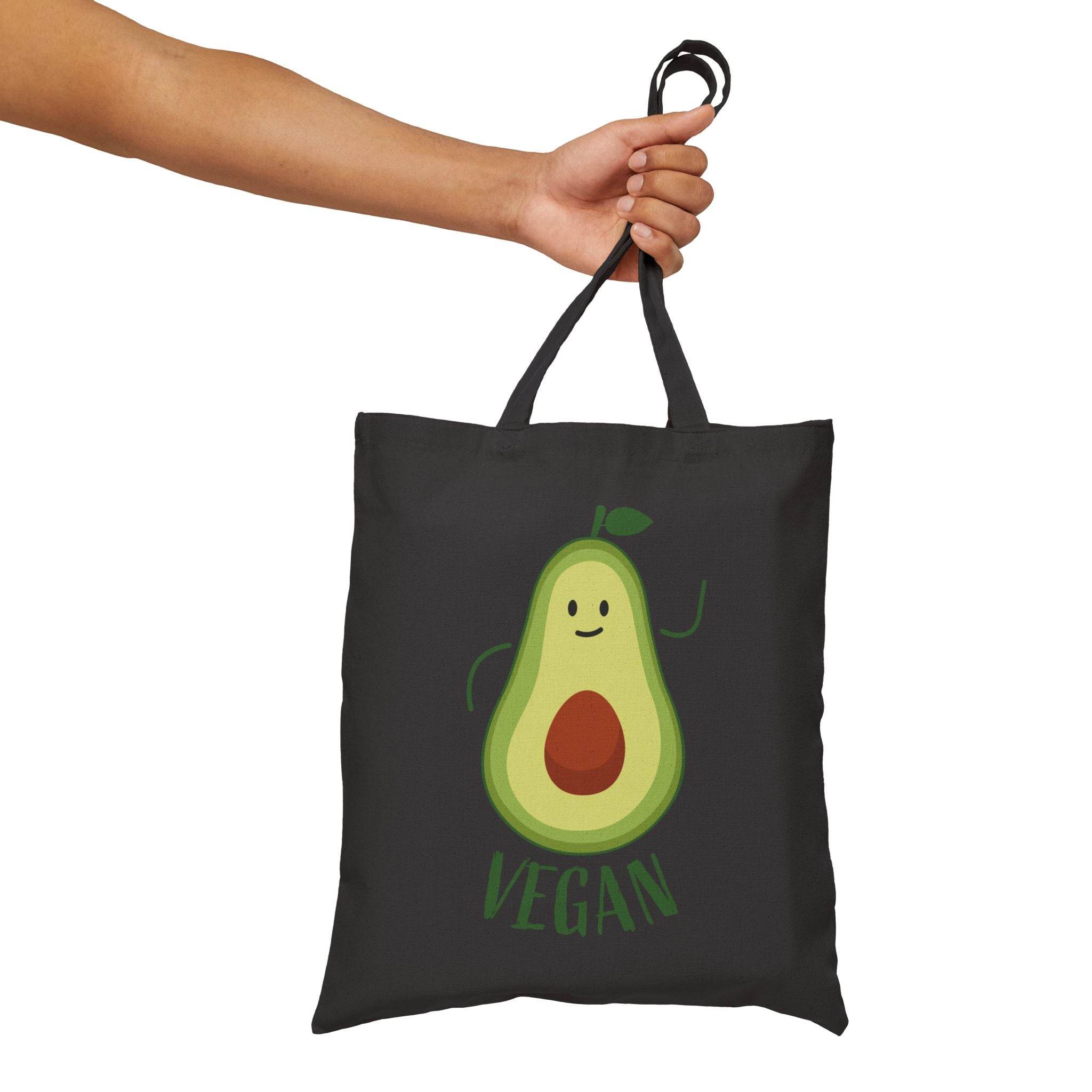 Printify eco-friendly cotton tote bag in black with cute vegan avocado design held by hand