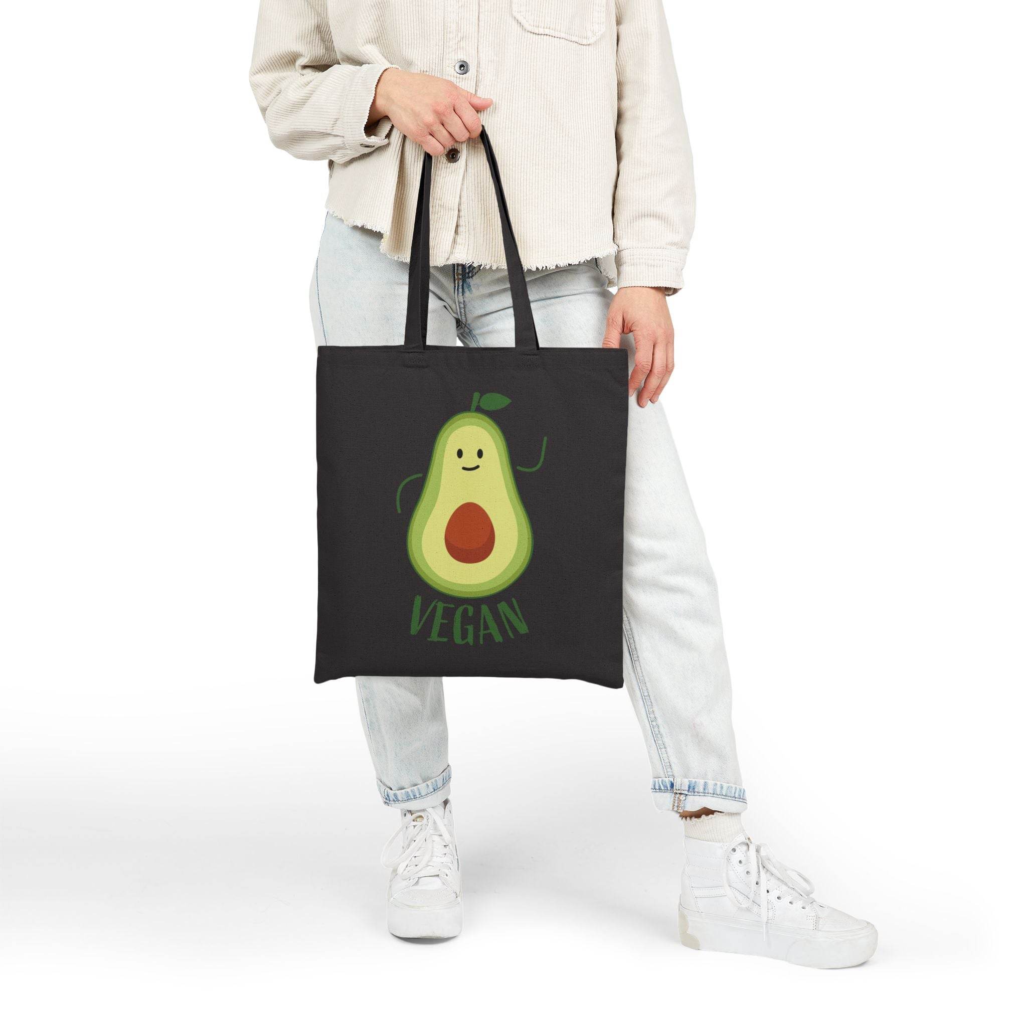 Printify eco-friendly cotton tote bag with cute vegan avocado design held by person in casual outfit