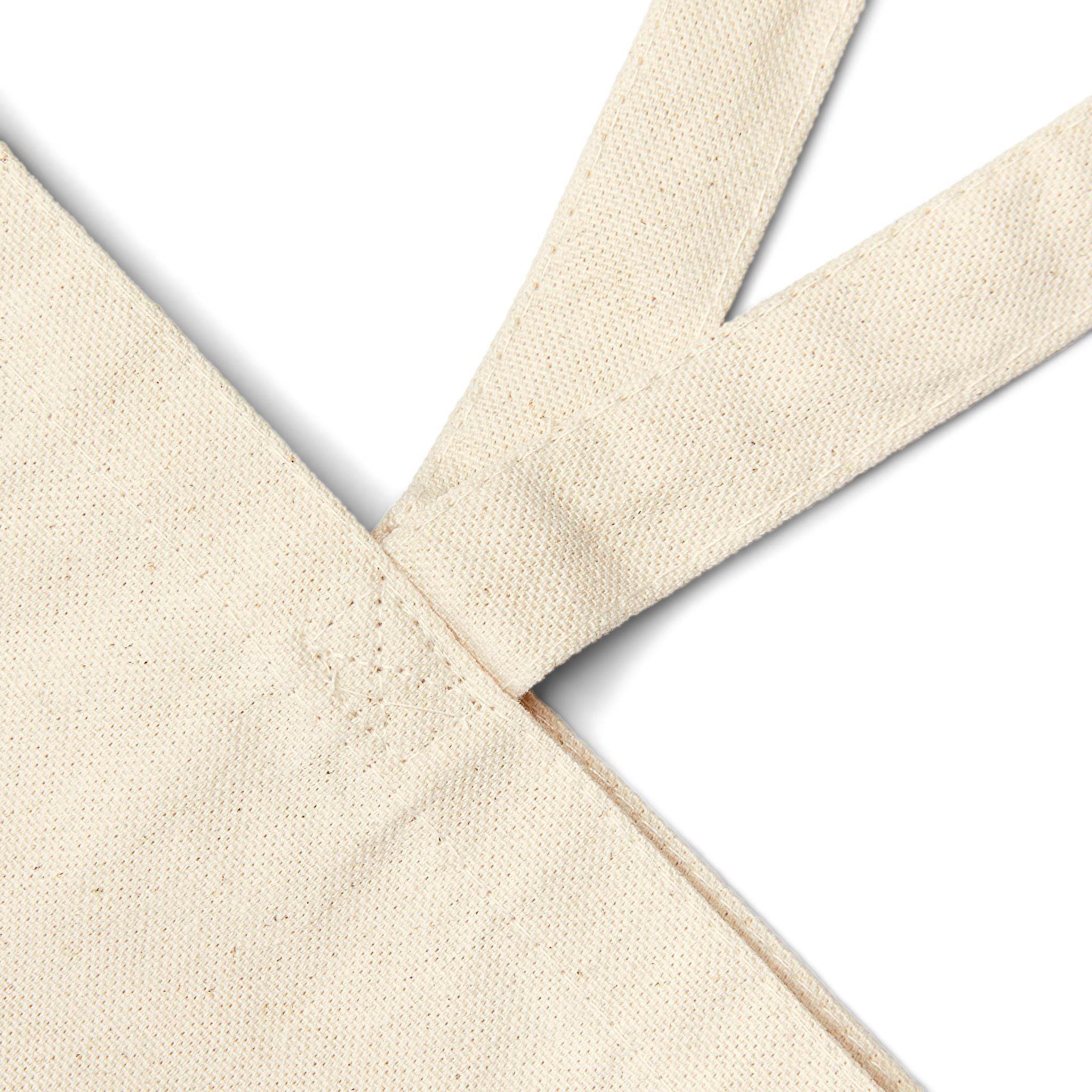 Close-up of eco-friendly cotton tote bag strap and corner showing natural fabric texture