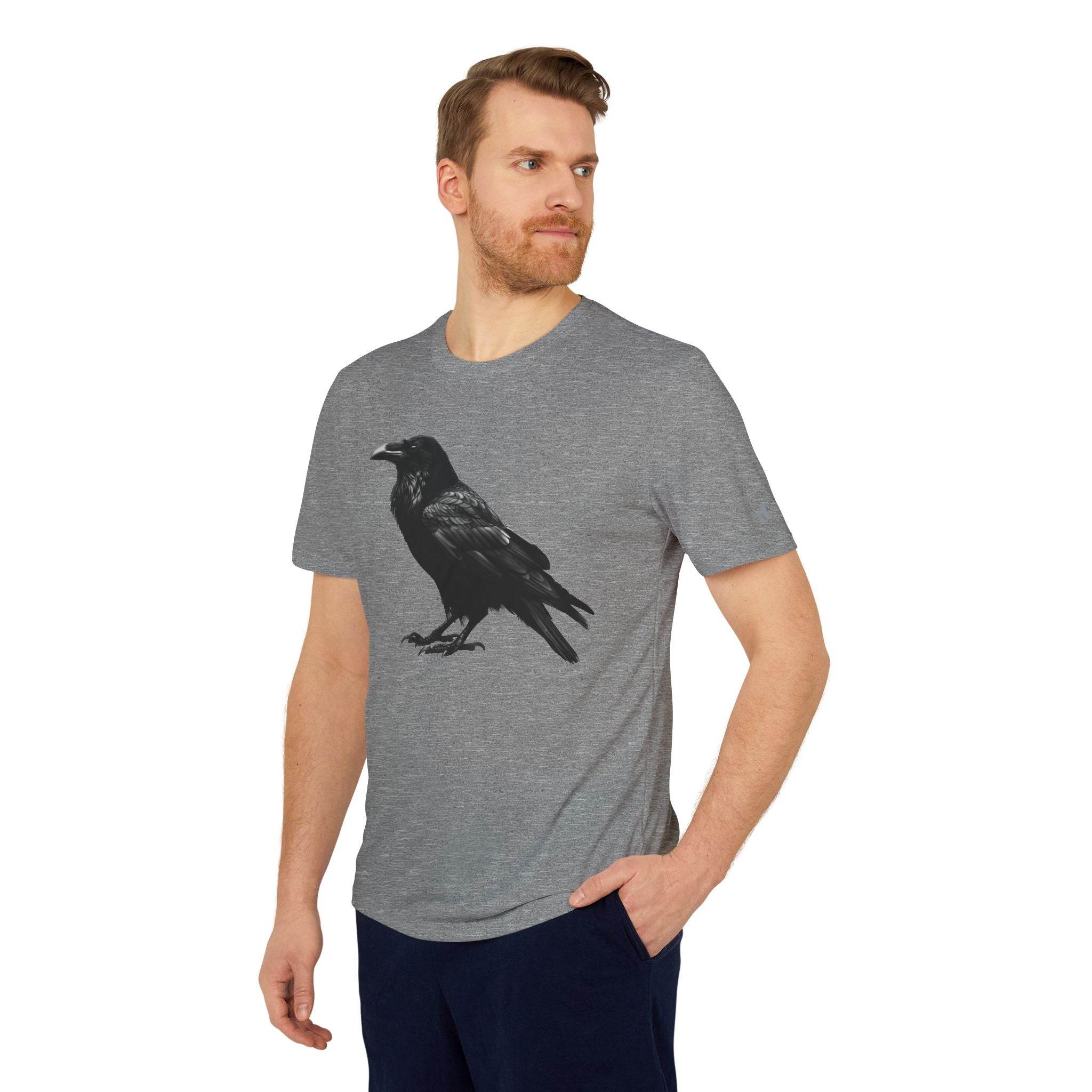 Man wearing a gray eco-friendly Adidas sport t-shirt with black crow graphic standing with hand in pocket