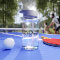 Clear BPA-free Tritan bottle with purple lid on blue ping pong table with paddle and ball