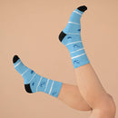 Printify blue recycled poly socks with anchor design and black toes and heels on raised feet