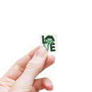Hand holding a green love design sustainable square sticker rolls by Printify on white background