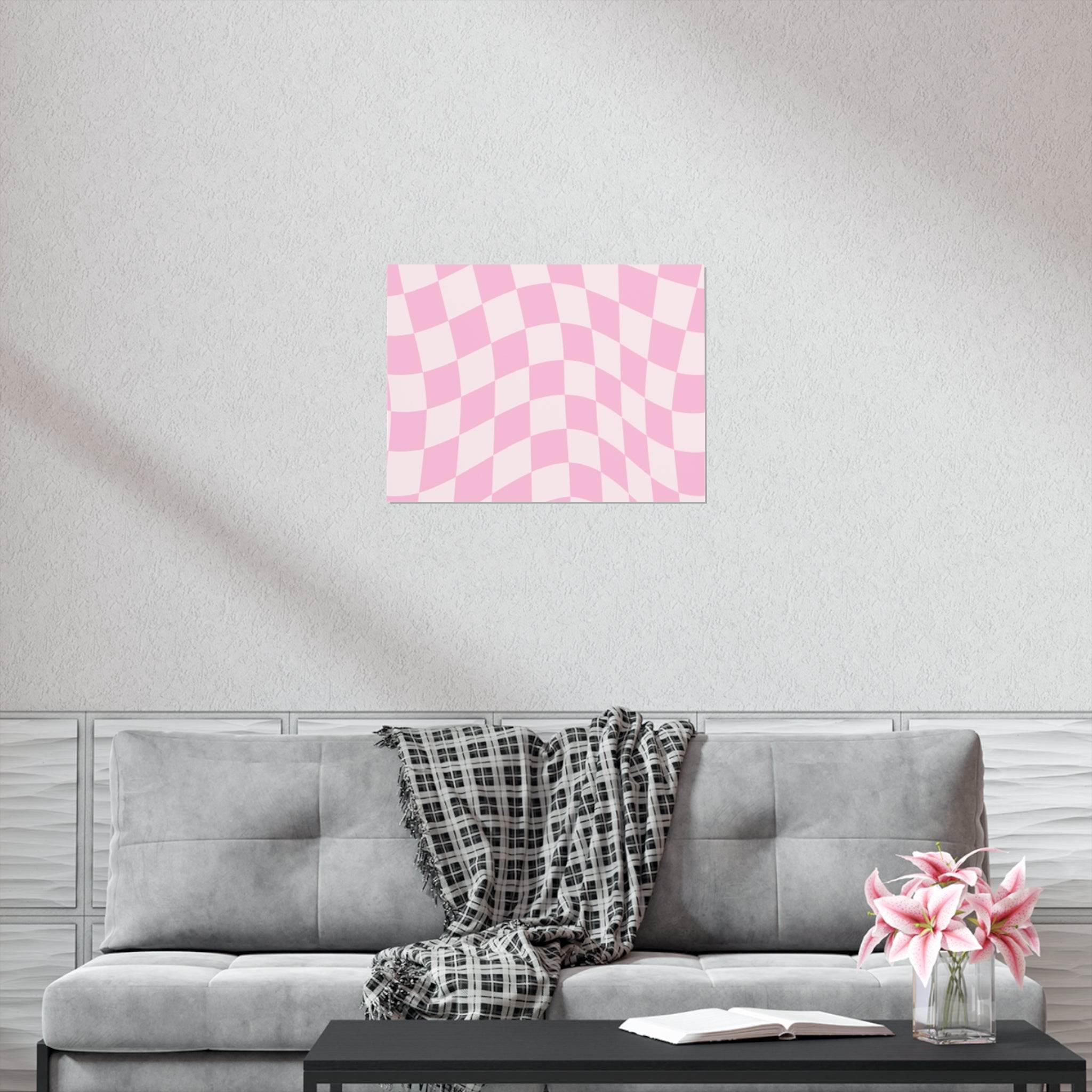 Pink and white checkered sustainable uncoated posters displayed on a living room wall above a gray sofa