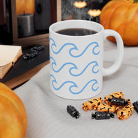 Printify ceramic mug with wave pattern filled with steaming coffee on a gray cloth with pumpkins and candy nearby