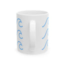 White ceramic mug with wave pattern in blue on both sides and a handle in the center