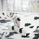 Printify Christmas tree wrapping paper with green tree design used to wrap holiday gifts near scissors and ribbon