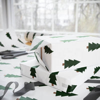 Printify Christmas tree wrapping paper with green tree design used to wrap holiday gifts near scissors and ribbon
