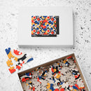 Colorful eco puzzle with red, blue, orange, and black abstract design pieces inside and outside a white Printify box