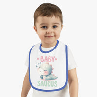 Toddler wearing a dinosaur print baby bib with a cute sleeping dinosaur and blue trim from Printify