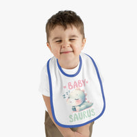 Smiling toddler wearing Printify dinosaur print baby bib with sleeping baby dinosaur design and blue trim