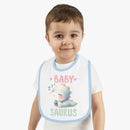 Toddler wearing a dinosaur print baby bib with a cute sleeping dinosaur design and blue trim
