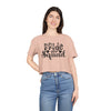 Woman modeling eco-friendly bride squad crop top in blush pink Printify tee with black script logo and short sleeves