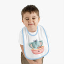 Toddler wearing Printify eco-friendly baby bib with blue trim and playful elephant sailor design