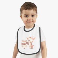 Toddler wearing eco-friendly baby bib with cute giraffe design and text from Printify
