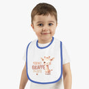 Toddler wearing Printify eco-friendly baby bib with blue trim and cute giraffe design