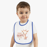 Toddler wearing Printify eco-friendly baby bib with blue trim and cute giraffe design