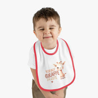 Eco-friendly baby bib with pink trim featuring a cute giraffe design and text worn by a smiling toddler