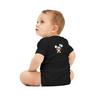 Baby wearing black eco-friendly baby onesie with teddy bear and balloon design sitting on white background