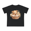 Black eco-friendly baby t-shirt by Printify with a cute teddy bear in a flower-adorned basket design