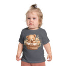 Toddler wearing Printify eco-friendly baby t-shirt with teddy bear in basket and floral design