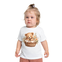 Toddler wearing eco-friendly baby t-shirt with teddy bear in basket and floral design