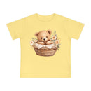 Yellow eco-friendly baby t-shirt with teddy bear in basket and floral design by Printify