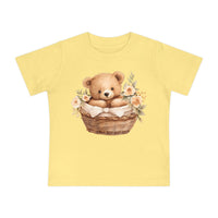 Yellow eco-friendly baby t-shirt with teddy bear in basket and floral design by Printify