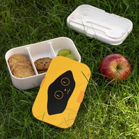 Eco-friendly bento lunch box with cute cat design, divided compartments with snacks on grass