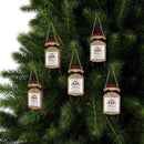 Eco-friendly Christmas ornaments shaped like sleds with Santa hats hanging on pine tree branches