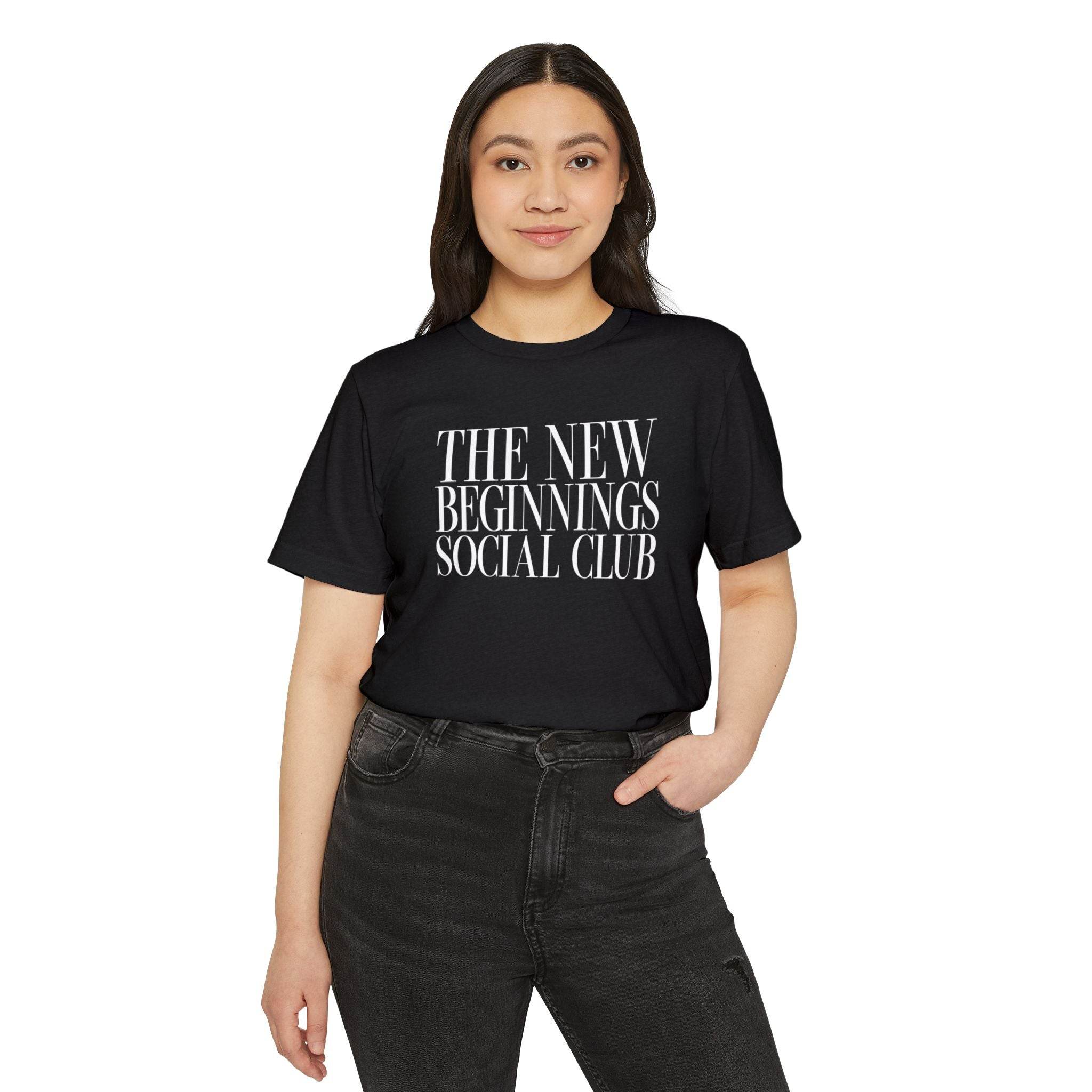 Printify black eco-friendly fashion tee with The New Beginnings Social Club text worn by woman