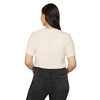 Printify eco-friendly fashion tee in beige with back text worn by woman with black jeans