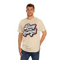 Man wearing beige eco-friendly graphic tee with Busy Doing Nothing text design from Printify