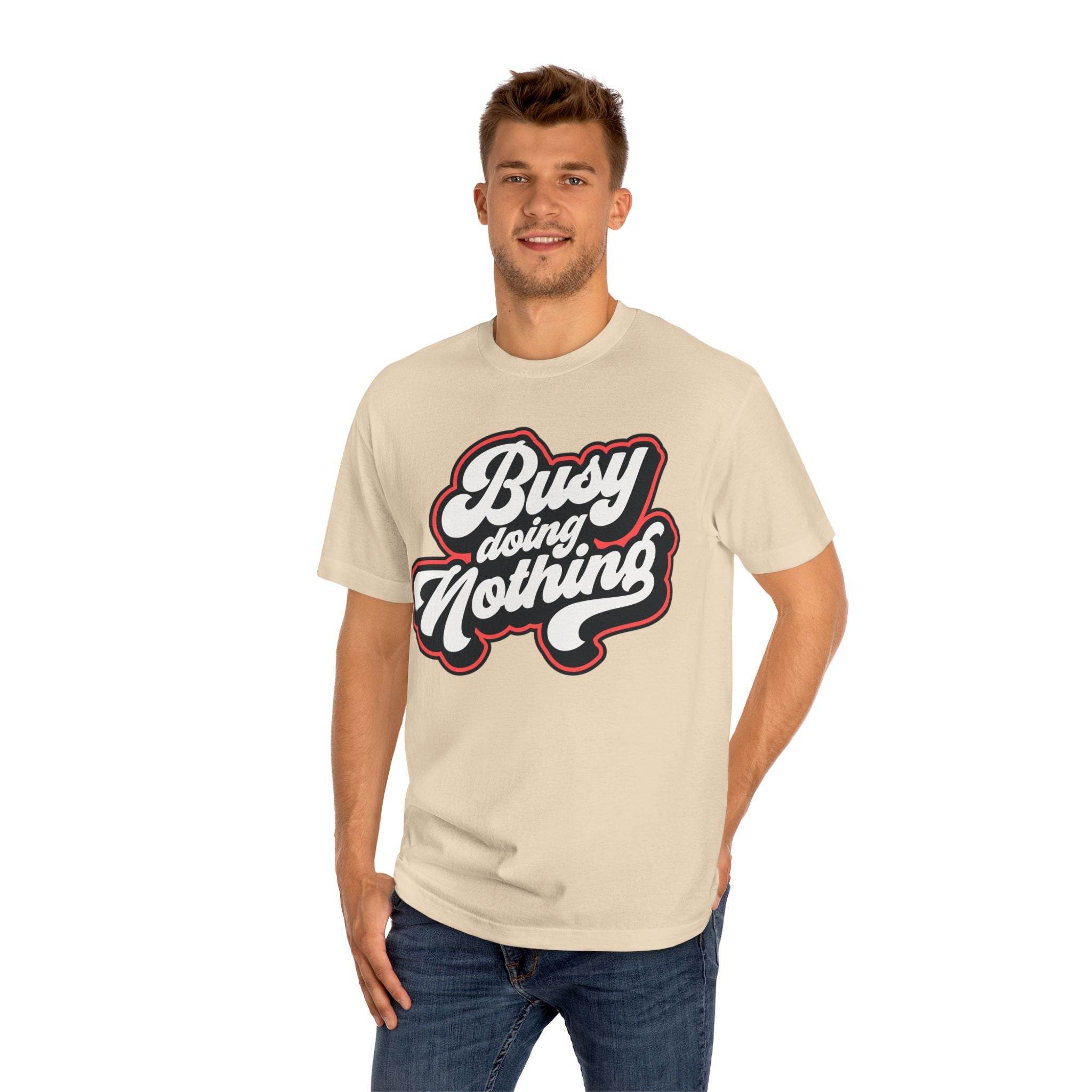Man wearing beige eco-friendly graphic tee with Busy Doing Nothing text design from Printify