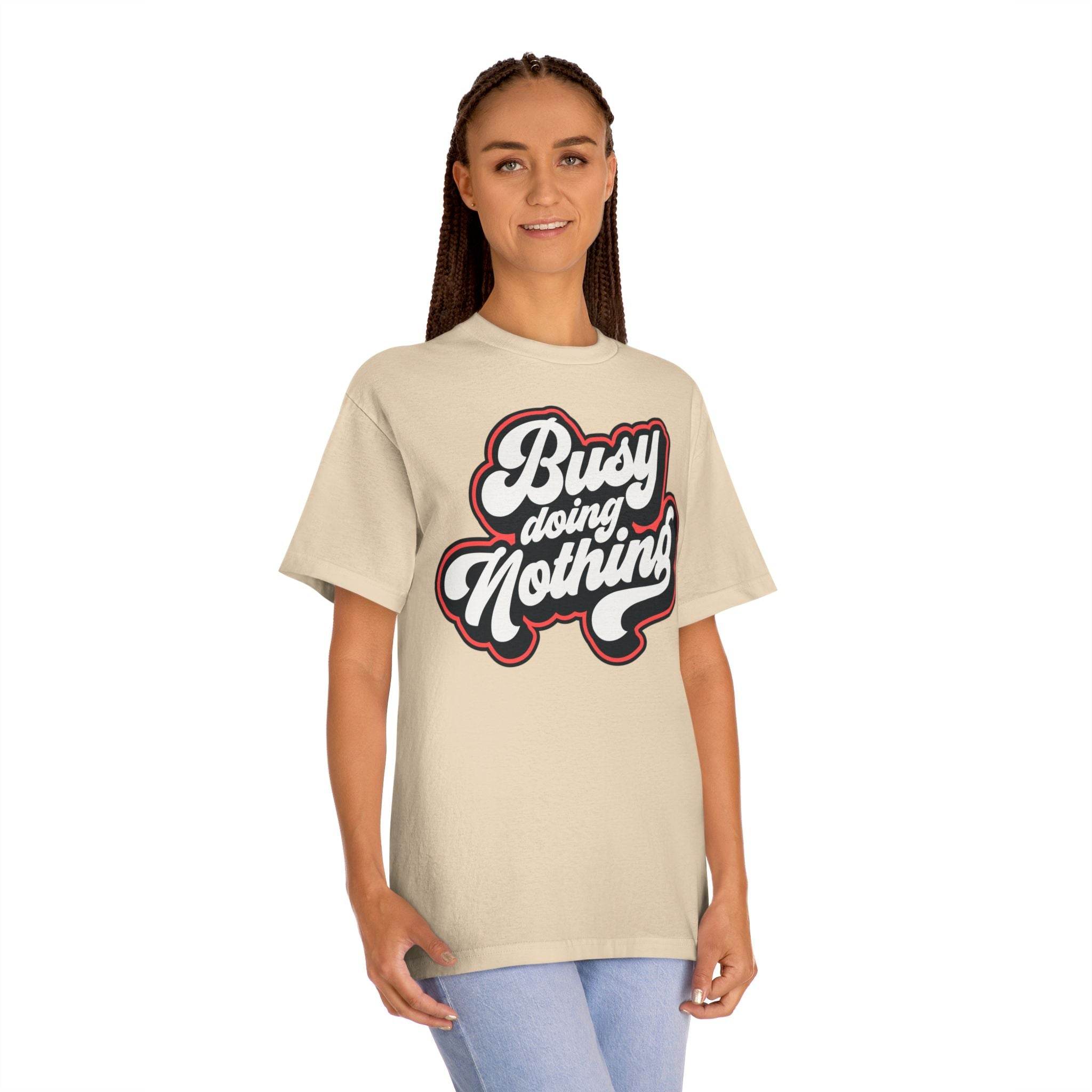 Printify beige eco-friendly graphic tee with Busy Doing Nothing text worn by model