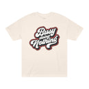 Printify beige eco-friendly graphic tee with Busy Doing Nothing text design in bold script