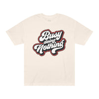 Printify beige eco-friendly graphic tee with Busy Doing Nothing text design in bold script