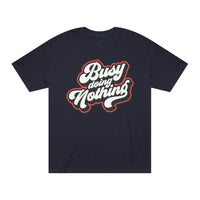 Printify black eco-friendly graphic tee with Busy Doing Nothing white and red text design