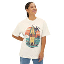 Printify eco-friendly oversized t-shirt with surfboard and palm tree graphic worn by smiling woman