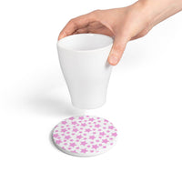 Hand holding white cup above eco-friendly pink ceramic coaster with star pattern from Printify