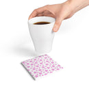 Hand holding white cup above eco-friendly pink ceramic coaster with star pattern on white background