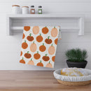 Printify eco-friendly pumpkin tea towels hanging on white kitchen shelf with spice jars and bread basket