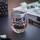 Printify eco-friendly whiskey glass with I am a creative soul text filled with whiskey on a dark surface