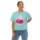 Printify eco-friendly women boxy tee in light blue with pink dice graphic worn by smiling woman