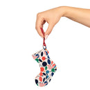 Hand holding colorful eco-friendly wooden ornaments shaped like a Christmas stocking with a red string