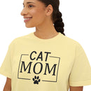 Printify eco-friendly cat mom shirt modeled by smiling woman in pale yellow tee with black CAT MOM text and paw print