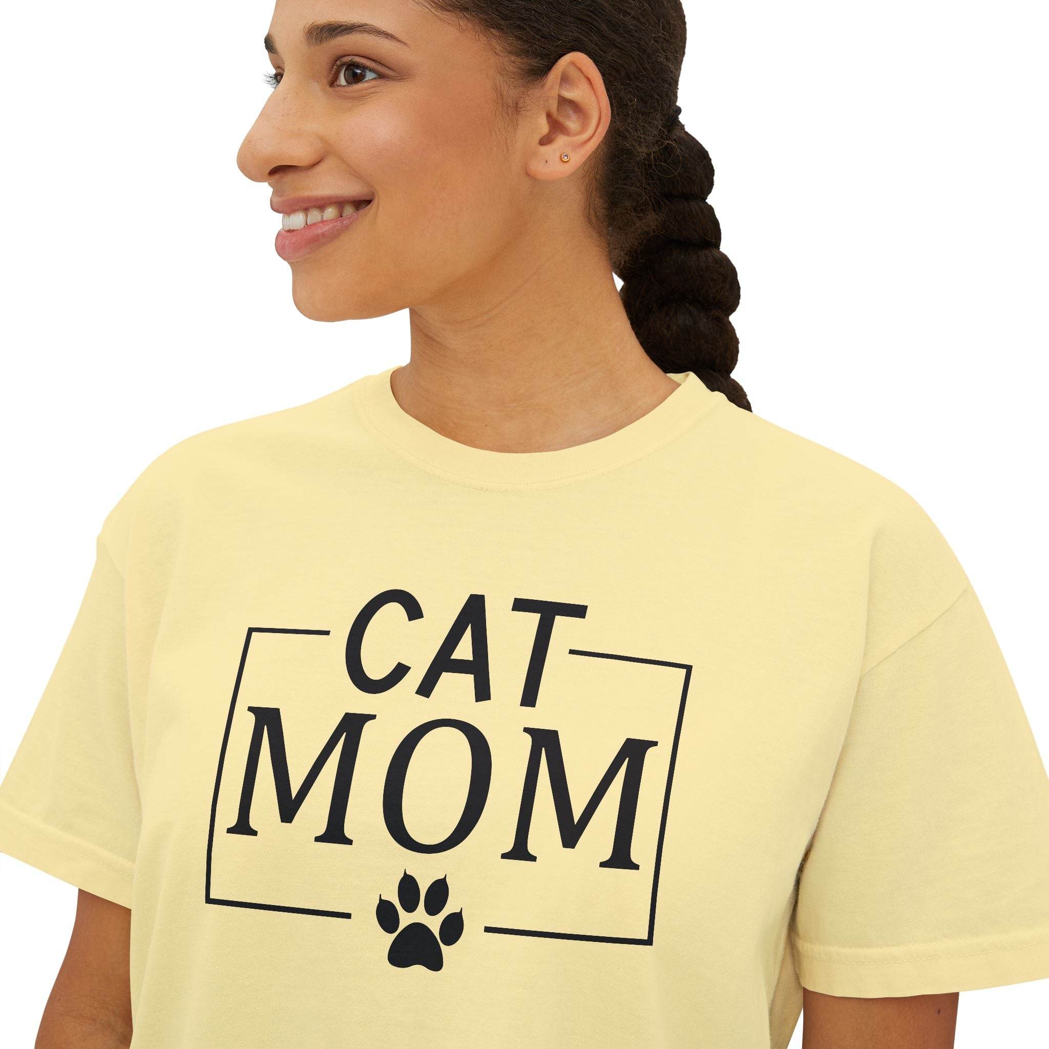 Printify eco-friendly cat mom shirt modeled by smiling woman in pale yellow tee with black CAT MOM text and paw print