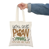 Printify eco-friendly paw print tote bag with You left paw prints on my heart design held by hand